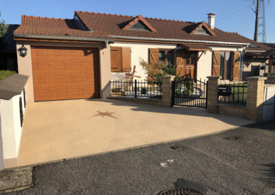 Une allée de garage en moquette de pierre aux couleurs de la façade